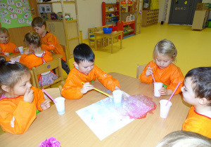 15 Dzieci kolorową pianę przekładają na biały karton tworząc obrazek